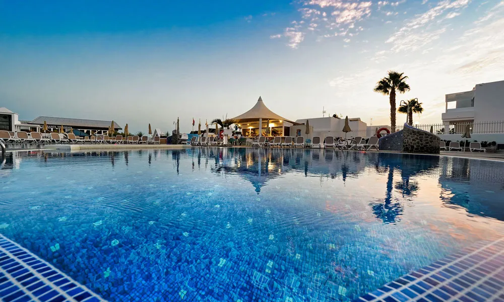 Poolblick bei Sonnenuntergang und Palmen Relaxia Lanzaplaya